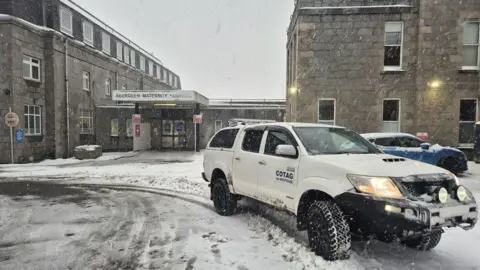 COTAG 4X4 Response A large white 4x4 car parked outside Aberdeen Maternity Hospital on a very snowy day