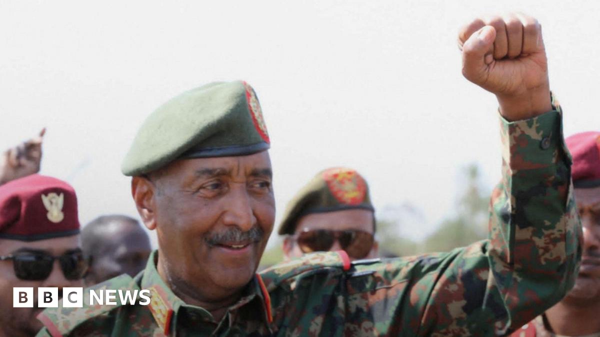 Gen Abdel Fattah al-Burhan, wearing military uniform and a green beret, clenches his fist in triumph