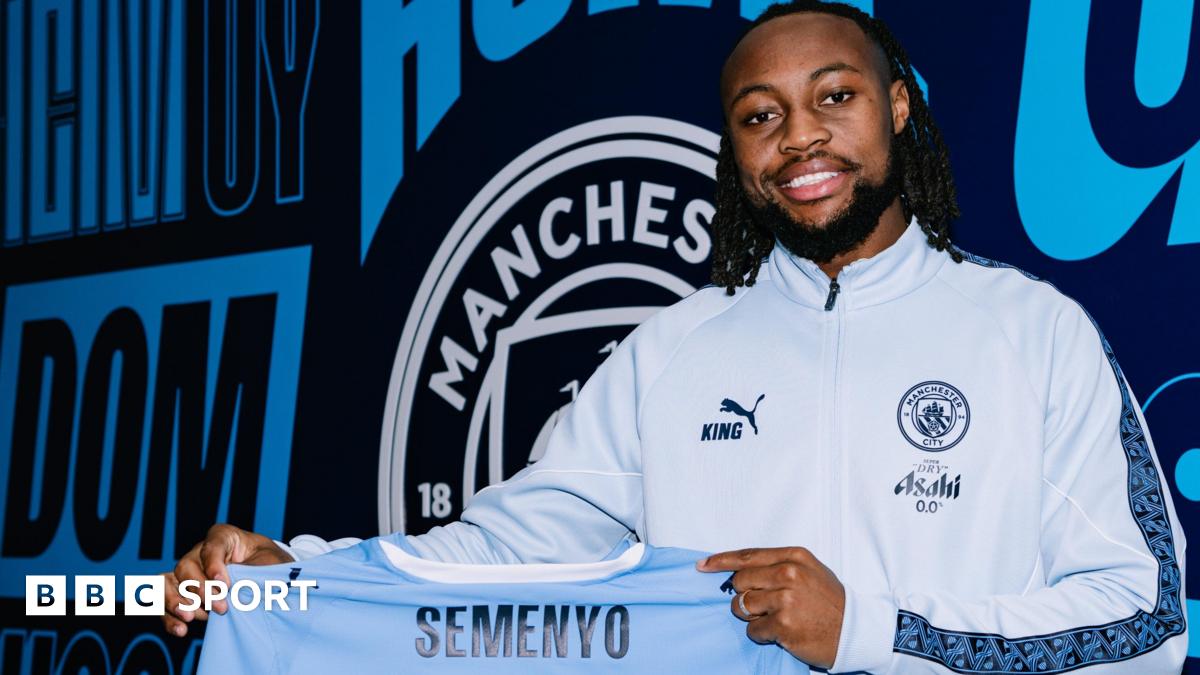 Antoine Semenyo holds a Manchester City shirt after signing for the club