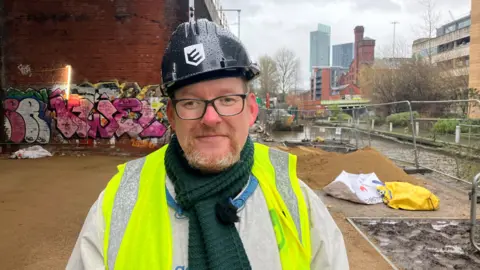 Photograph of Laighton Walters from the homeless charity Embassy. He is pictured underneath railway arches at the Embassy homeless village in Castlefield.
