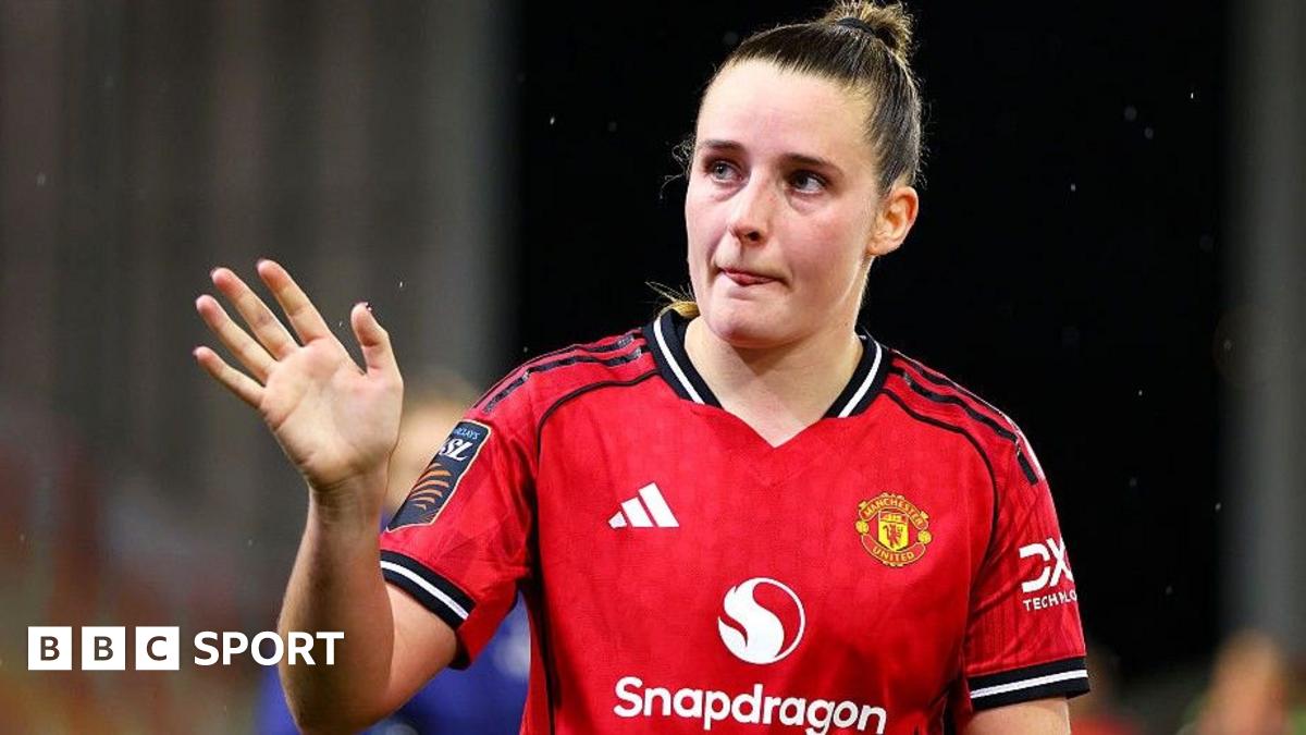 Ella Toone gives a signal with her right hand as she wears Manchester United's large red home shirt