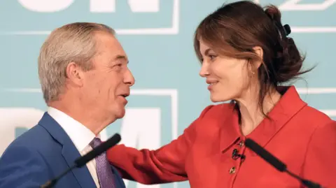 PA Media Nigel Farage and Laila Cunningham embrace at a podium in front of a press conference