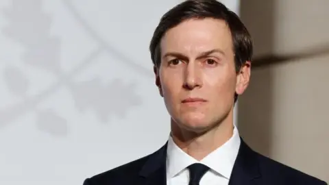 EPA An image of Jared Kushner dressed in a black suit with a white shirt staring off into the distance. 