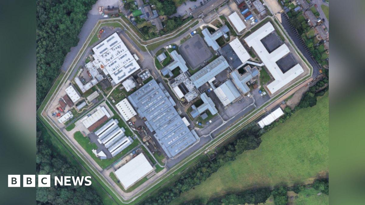 Donald Trump and Keir Starmer sit in a formal drawing room setting  on arm chairs with US and UK  flags behind them. Both have serious expressions and are looking out and not at each other.