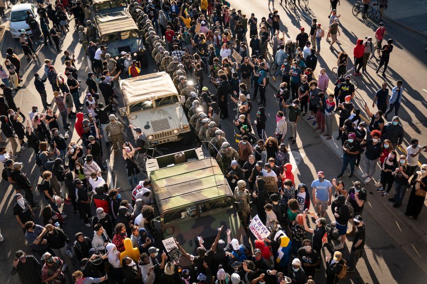 A group of protesters surrounded several National Guard vehicles that were driving on Lake Street towards the blockade under the Hiawatha Light Rail station and forced them to reverse out in Minneapolis in May 2020.