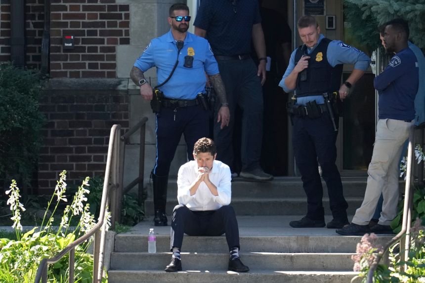 Minneapolis Mayor Jacob Frey sits on steps of the Annunciation Church's school as police respond to a reported mass shooting on August 27, 2025.