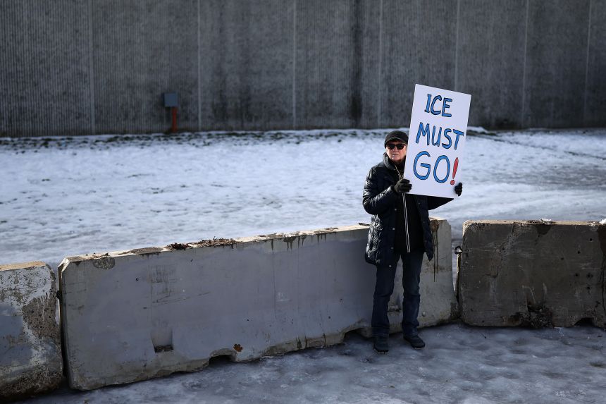 A protester holds a sign near the Bishop Henry Whipple Federal Building in Saint Paul, Minnesota, on January 9. 