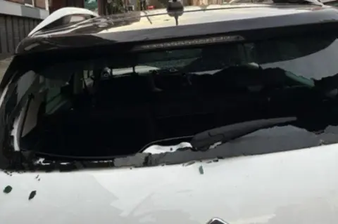 Facebook Smashed back window of white car shows broken glass