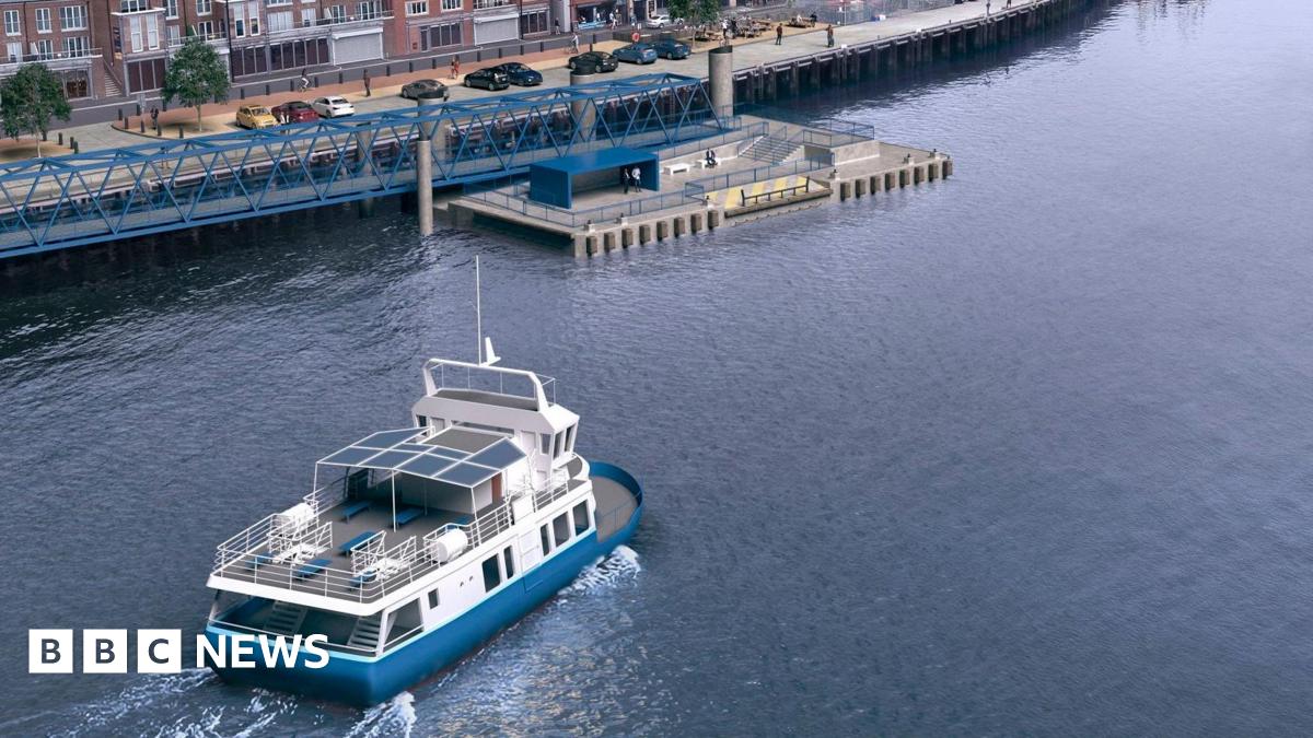 A computer-generated image to show the Shields Ferry on the River Tyne and approaching a new landing at the edge of North Shields Fish Quay. The ferry is blue and white and has an enclosed lower deck and a top deck that is open at the back but has a canopy at the front. Beyond the ferry is the floating pontoon at which passengers embark and disembark and, beyond that, are cars parked along the edge of the fish quay, with buildings and a couple of trees behind.