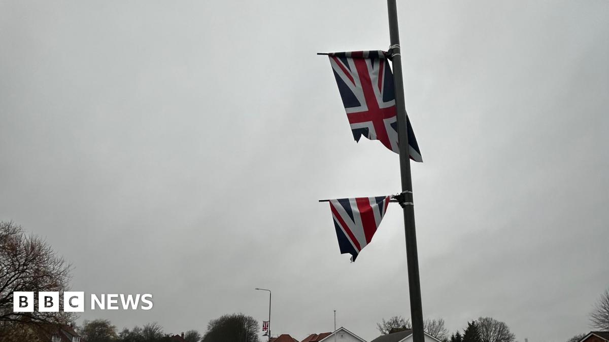 A union flag cut in half on a flag pole