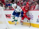 Detroit Red Wings defenceman Moritz Seider is drilled by Vancouver Canucks forward Kiefer Sherwood during the first period on Jan. 8 in Detroit.