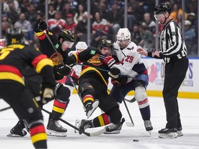 Washington Capitals' Hendrix Lapierre (29) checks David Kampf (64) as Drew O'Connor (18) skates after the puck during the first period