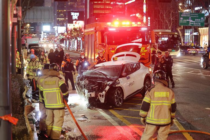 Firefighters inspect the site of a car crash near Jonggak Station in central Seoul, Friday, which killed one pedestrian. Yonhap