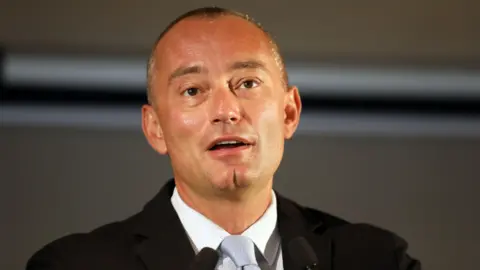 Getty Images Nickolay Mladenov speaks at a podium.