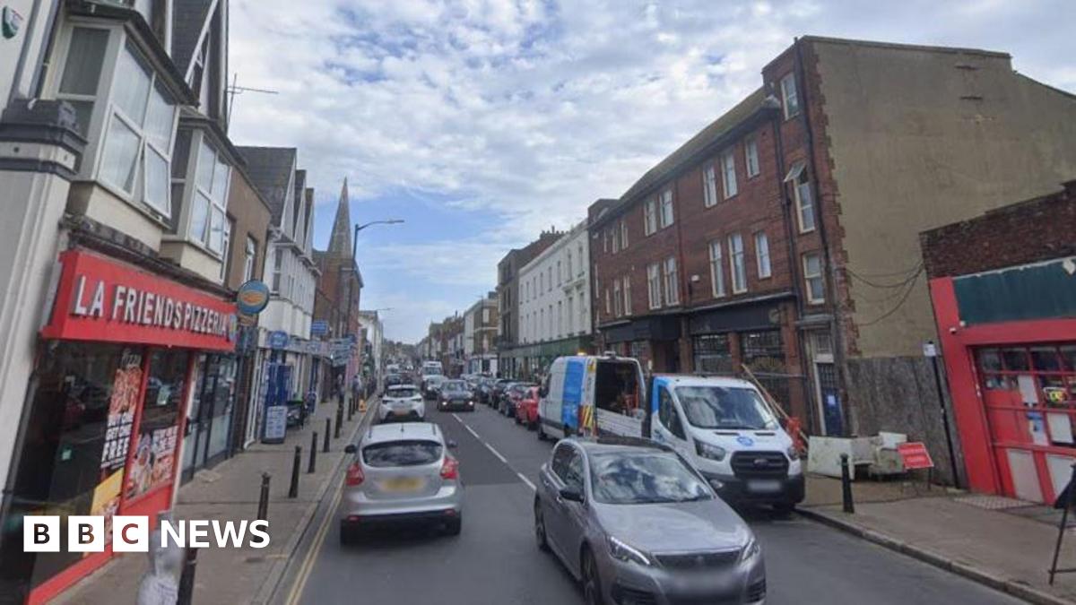 Cars and shops on a busy street.