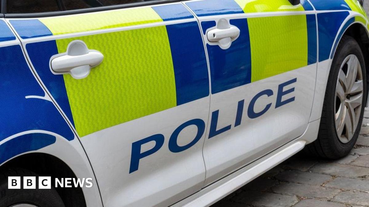 White police car with blue and yellow markings and POLICE in large blue letters.