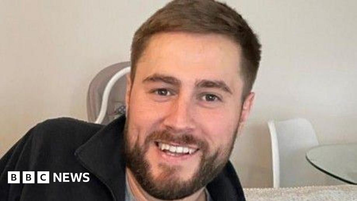 Prime Minister Mark Carney, wearing a black suit jacket, and a white button-up shirt leans his chin on his hands. He has short grey and black hair and is looking away from the camera.