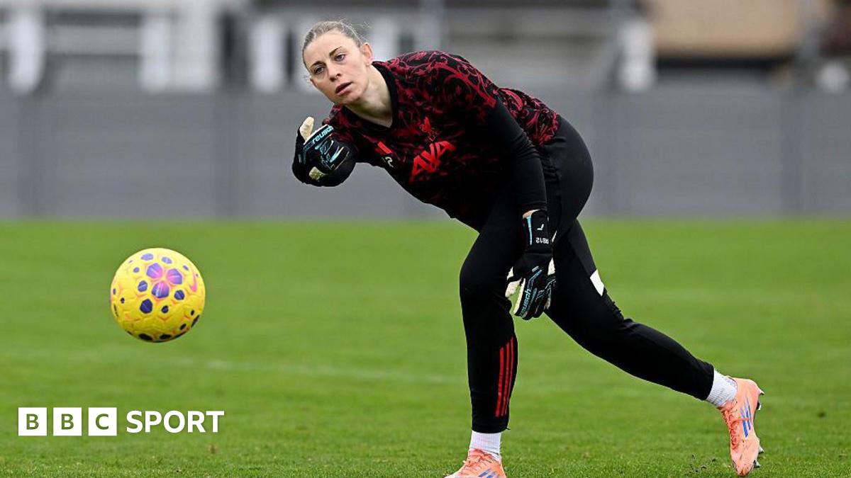 Rafaela Borggrafe rolls a yellow football while wearing black and red goalkeeper kit
