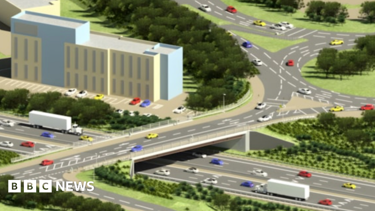 An animated diagram impression of Badminton Road Bridge. This picture includes multiple dual carriageways with cars and lorries using them. All the multi-coloured vehicles are heading in different directions. The diagram has patches of green grass, trees and bushes. There is one multi-storey building and car park in the centre of the diagram.