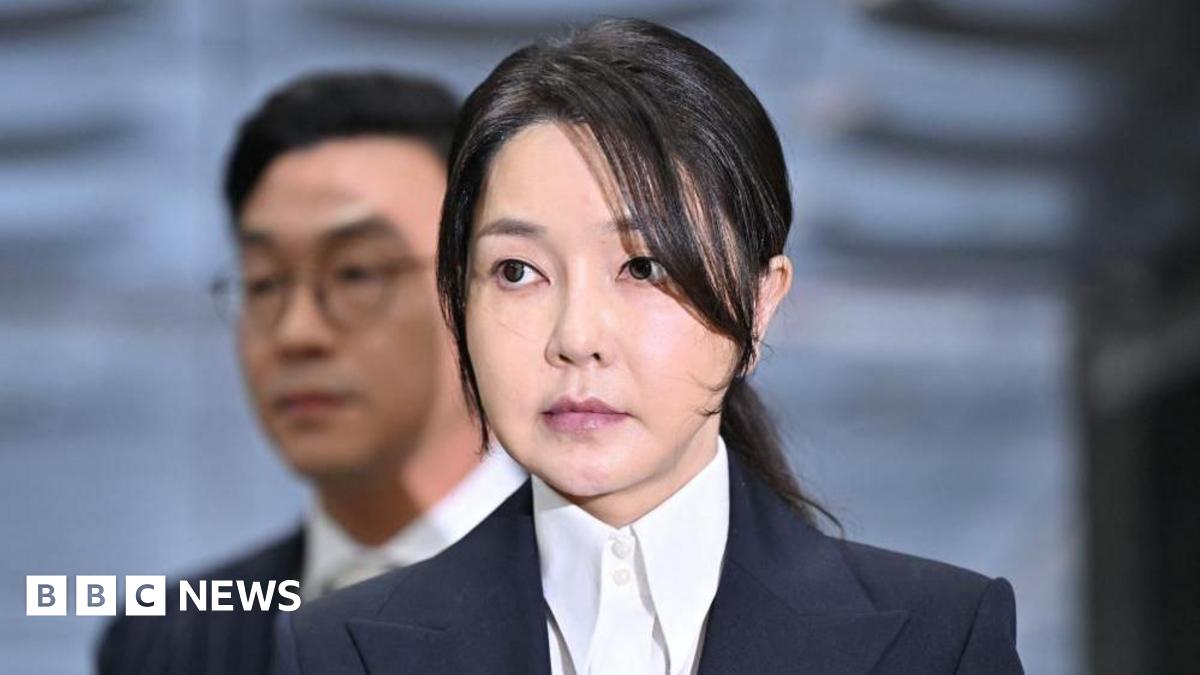 Kim Keon Hee, in a white dress suit and black blazer, arrives in court in Seoul to attend a hearing