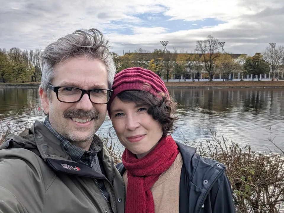 The writer and her husband standing in front of a pond.
