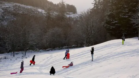 Cathal McNaughton/Reuters People play in the snow, as cold weather warnings are extended into next week by Britain's Met Office, in Glenariffe, Northern Ireland,