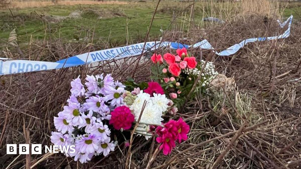 Flowers on some grass under some police tape