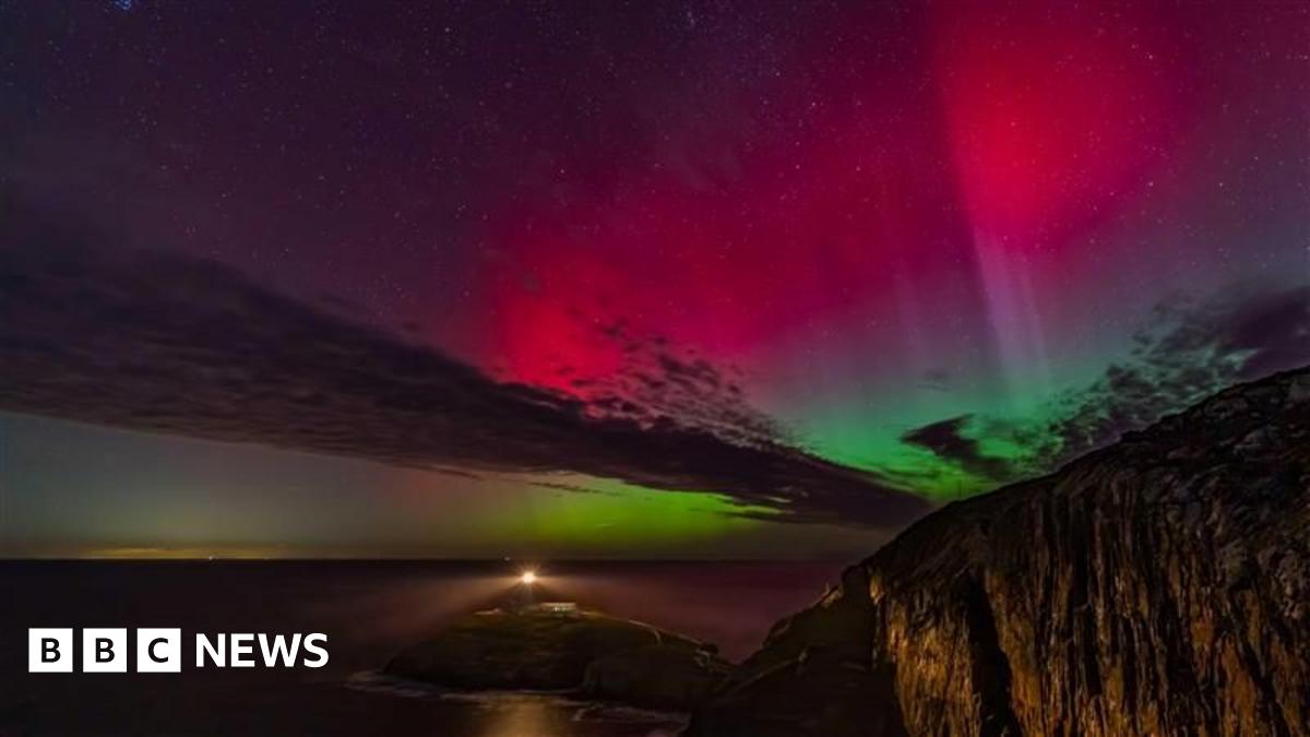 Donald Trump and Keir Starmer sit in a formal drawing room setting  on arm chairs with US and UK  flags behind them. Both have serious expressions and are looking out and not at each other.