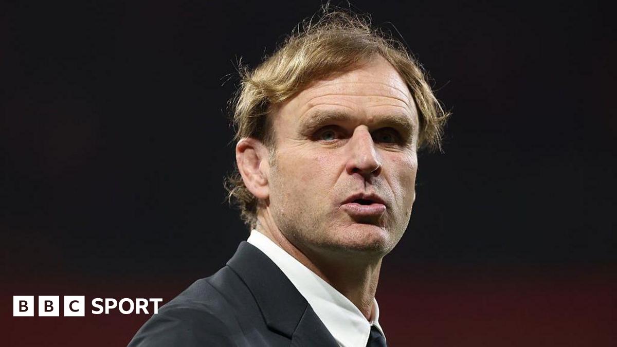 Head and shoulders view of Scott Robertson, who is wearing a white shirt with a collar and a dark suit jacket and looking slightly to his right in the direction of the camera