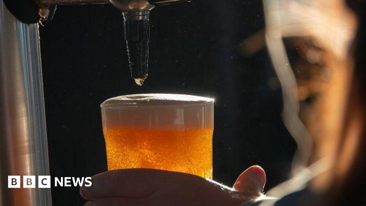 A golden pint of beer that has just been poured with a foaming head