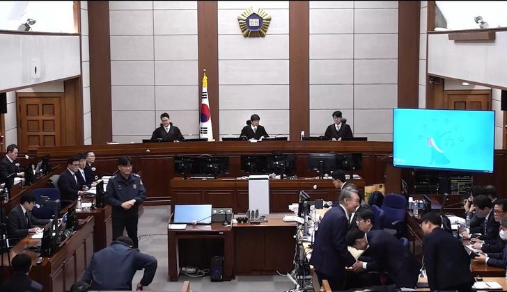 Former President Yoon Suk Yeol shakes hands with members of his legal counsel following a marathon 15-hour insurrection trial session at the Seoul Central District Court on Friday. Newsis