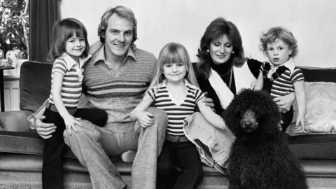 Getty Images Terry Yorath and his family in a black and white image.  His wife Christine with daughters and Louise and son Daniel.