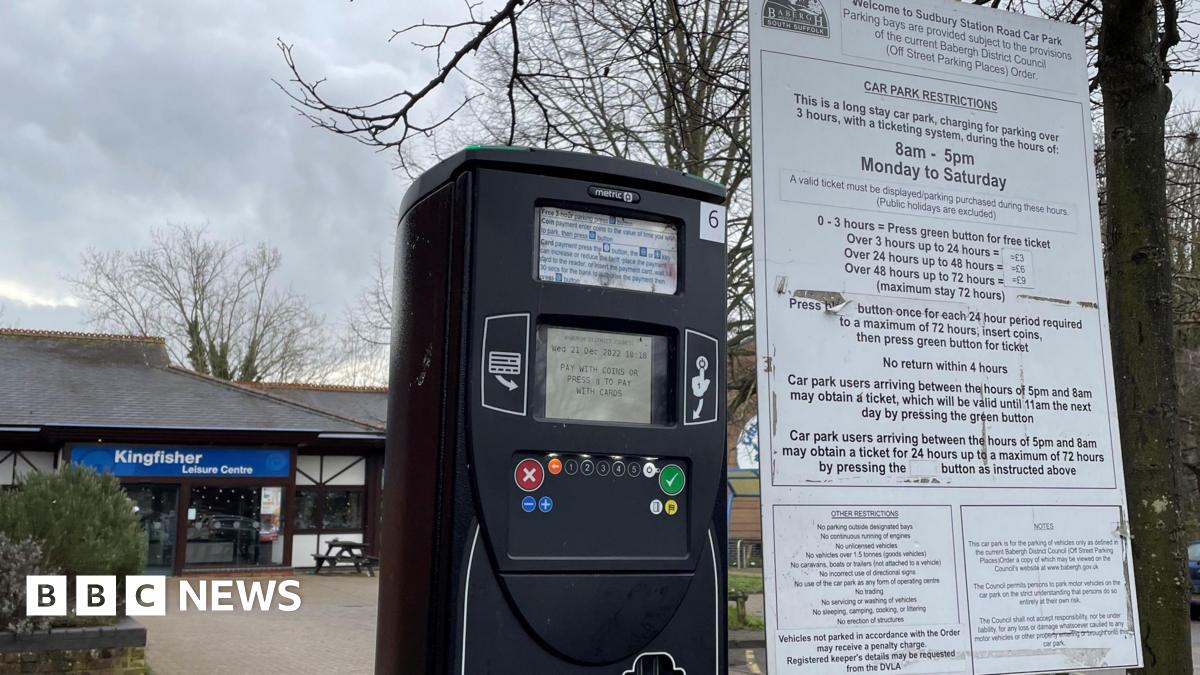 A sign and a parking machine in a car park