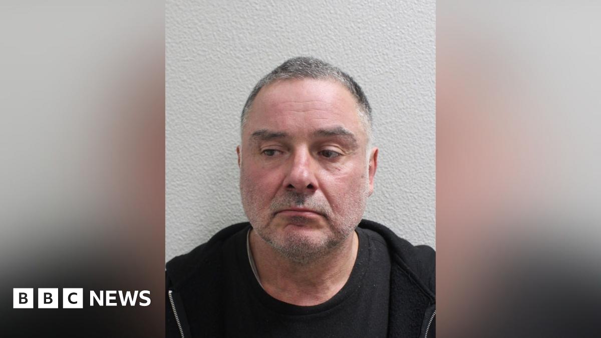 Custody image of Thomas McKenna, wearing a dark top, photographed against a plain wall.