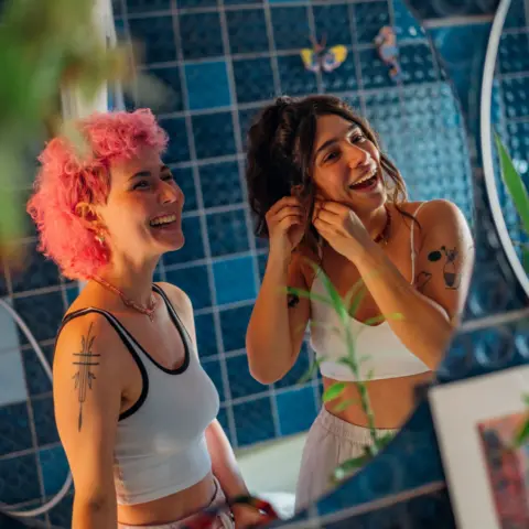 Getty Images Young women chatting and getting ready