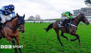 Jonbon and Thistle Ask clear the last fence and race towards the line. Jonbon's jockey, James Bowen, is wearing a white cap and a green-and-gold top. Thistle Ask is being ridden by Harry Skelton, who has a blue cap and top with lighter blue dots.