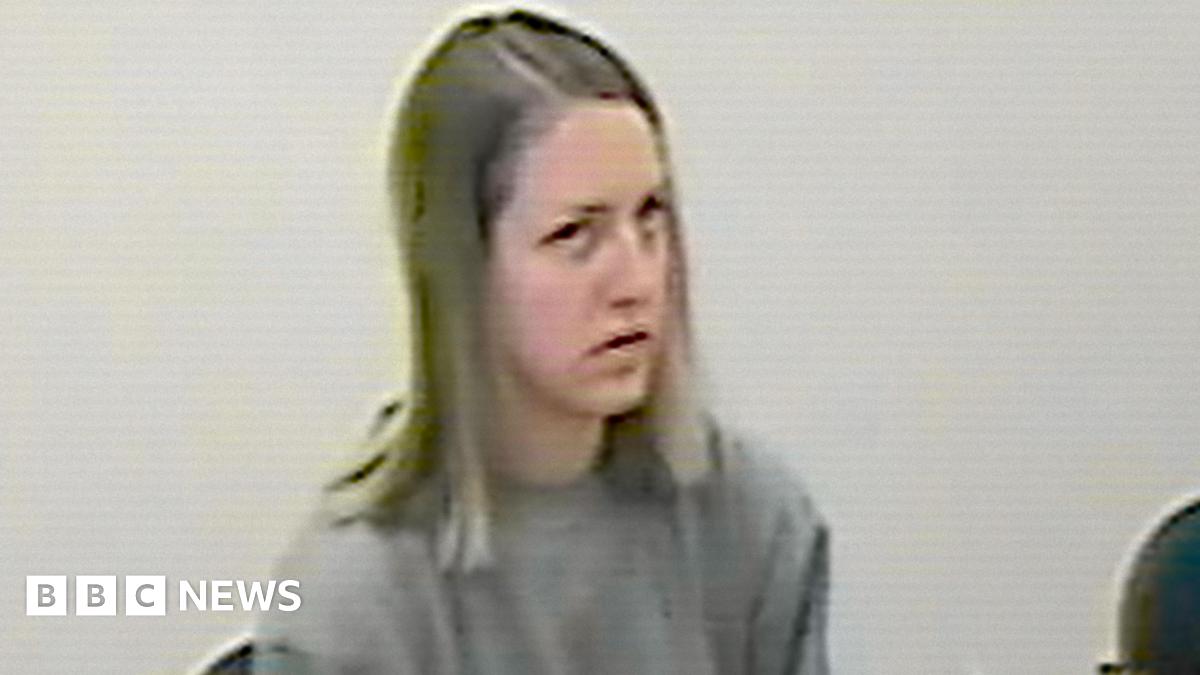 CCTV footage of Lucy Letby, who has shoulder length blonde hair and wears a plain grey jumper, sitting in a police interview room.