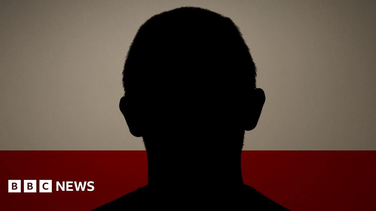 A silhouette of a man having his picture taken for a mugshot