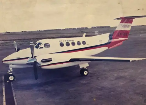 Hussein Mohamed Anshuur A small Bluebird plane with propellers parked on a runway