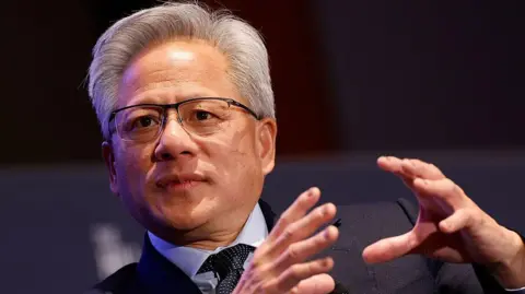 Getty Images CEO of Nvidia Jensen Huang speaks on AI at the return of American manufacturing at the Hill and Valley Forum at the US Capitol. He is dressed formally in a dark suit and gesturing with his hands  