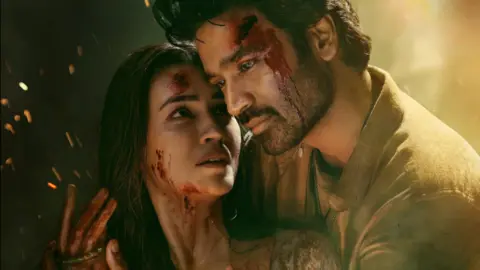 T Series Films In a poster for Tere Ishk Mein, actors Dhanush and Kriti Sanon are seen with bloody bruises on their faces