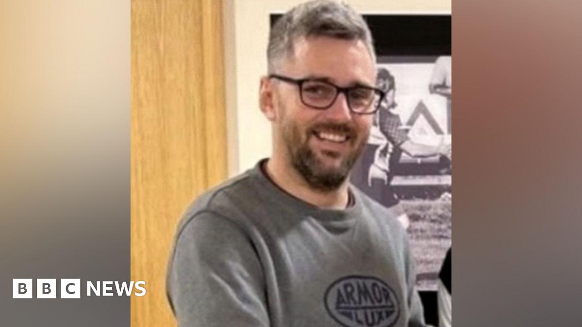 Craig Hurcombe is wearing glasses, has short greying hair and has facial hair. He is smiling at the camera.