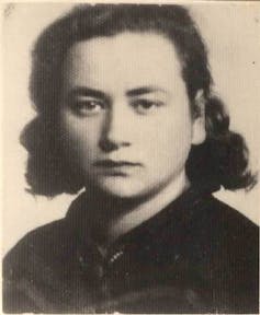 A black-and-white, close-up portrait of a girl with dark hair and a serious expression.