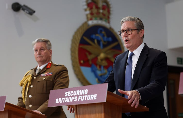 Starmer speaking at a lectern with a placard that says 'securing britain's future'