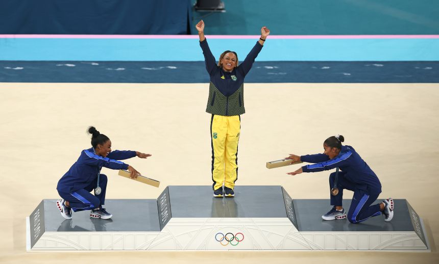 Americans Simone Biles, left, and Chiles bow to Brazilian gold medalist Rebeca Andrade after the floor exercise event at the Paris Olympics.