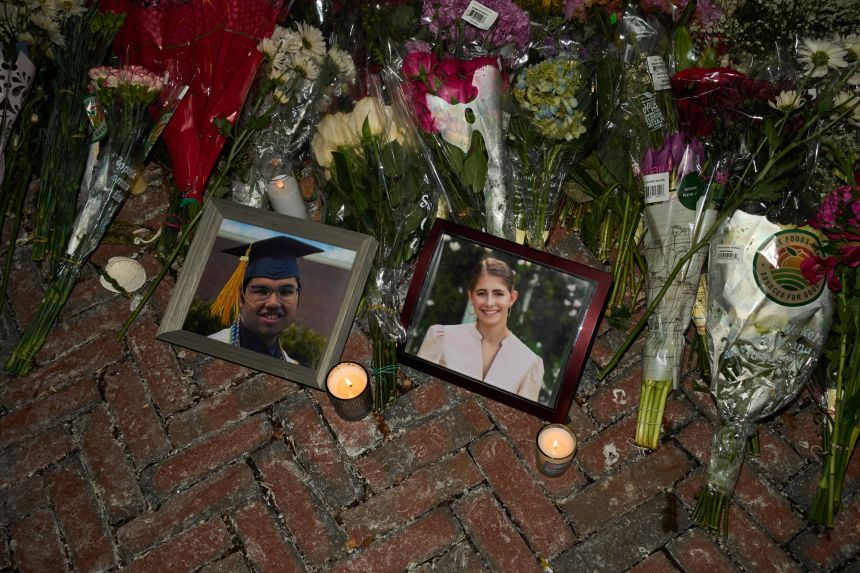 Candles flicker December 15 near framed photos of mass shooting victims MukhammadAziz Umurzokov and Ella Cook at a makeshift memorial near Brown University.