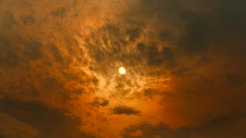 MELBOURNE, VICTORIA, AUSTRALIA - 2026/01/09: The sun casts an orange hue across the sky as smoke from bushfires drifts over Docklands. Smoke from multiple bushfires and grassfires burning the city is affecting air quality and visibility, turning the sky red. The Department of Environment, Land, Water and Planning (DELWP) has issued a community information message advising that smoke and ash may be seen or smelled in areas far from the fires. Residents are urged to take precautions especially those with respiratory conditions as bushfire activity continues. (Photo by Ye Myo Khant/SOPA Images/LightRocket via Getty Images)