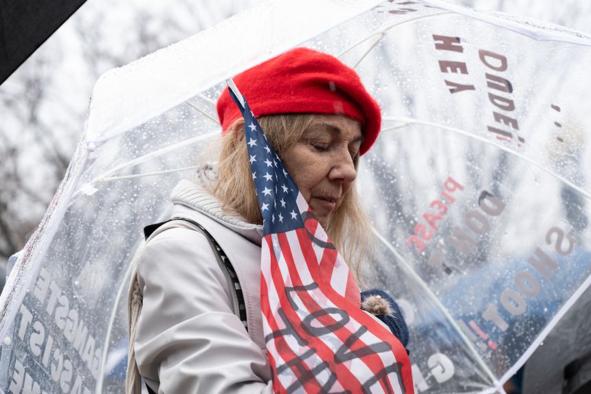 Kelly Donovan closes her eyes during a moment for silence for Renee Nicole Good while other demonstrators gather at Lafayette Park in front of the White House for a protest against the Trump administration on Saturday in Washington, DC.
