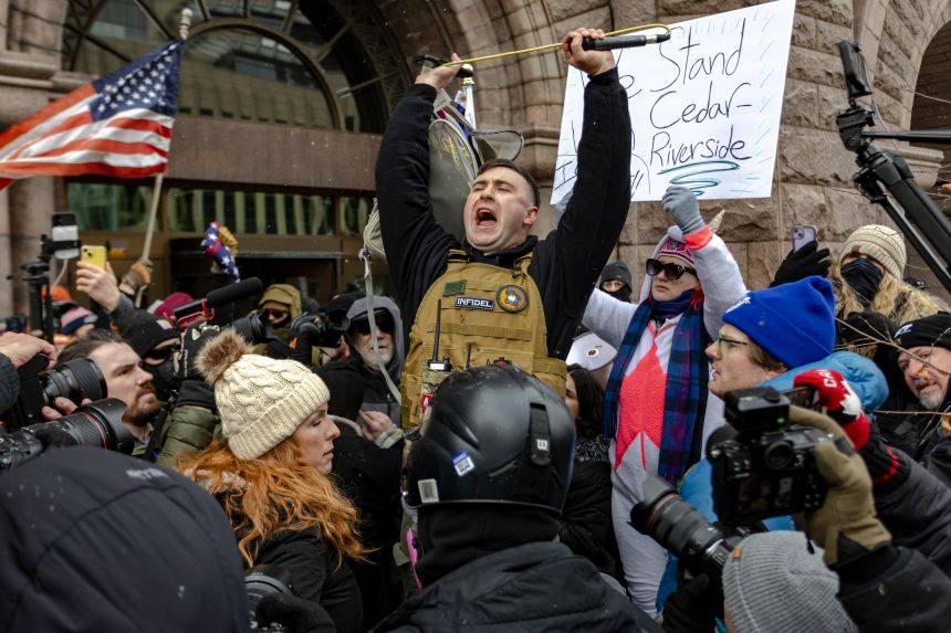 Right-wing influencer Jake Lang is confronted by protesters at a rally near City Hall on January 17, 2026, in Minneapolis.