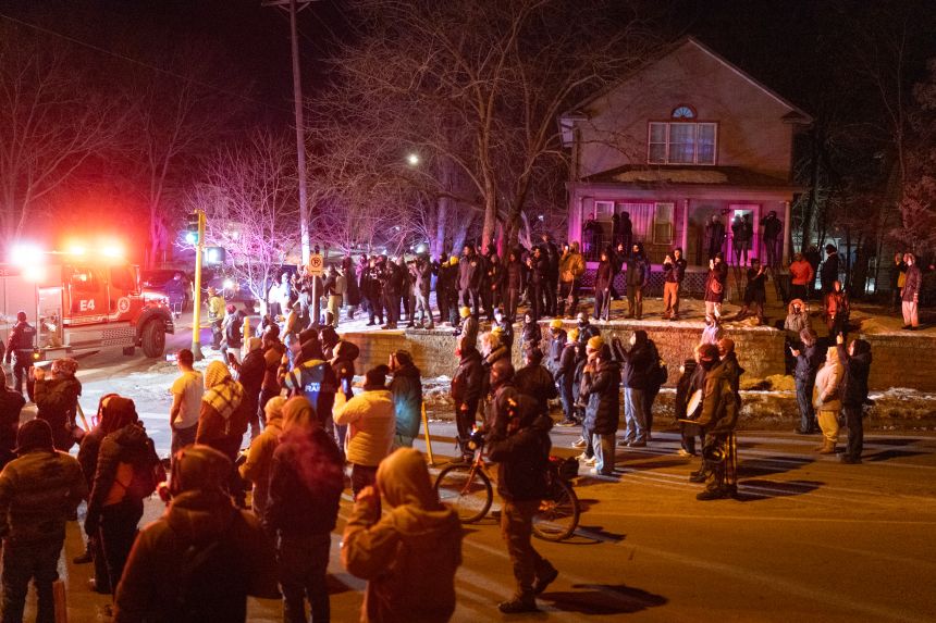 Residents confront federal agents following a shooting incident Wednesday in Minneapolis.